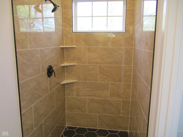 full bath featuring tiled shower and plenty of natural light