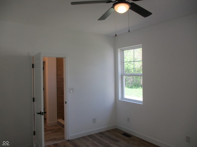 unfurnished room with wood finished floors, ceiling fan, and baseboards