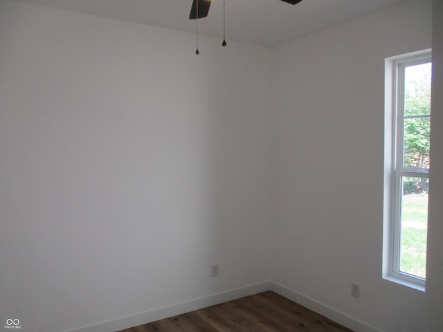 unfurnished room with healthy amount of natural light, wood finished floors, a ceiling fan, and baseboards