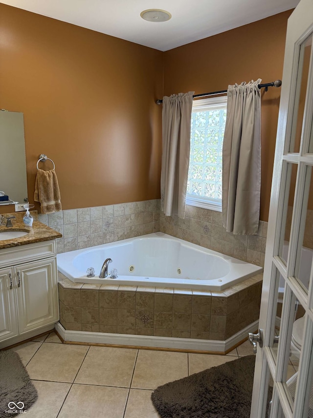 bathroom featuring tile patterned flooring, vanity, and a jetted tub