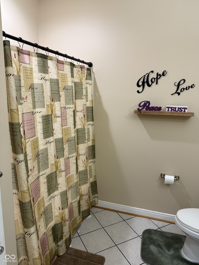 bathroom with baseboards, toilet, and tile patterned floors
