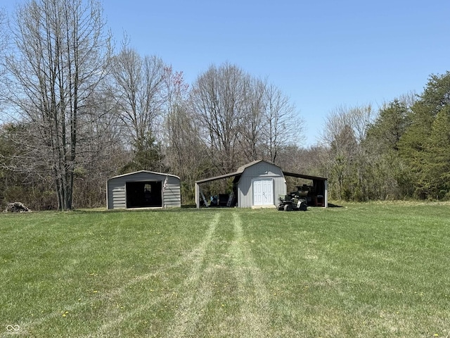 view of yard featuring a detached garage and an outbuilding