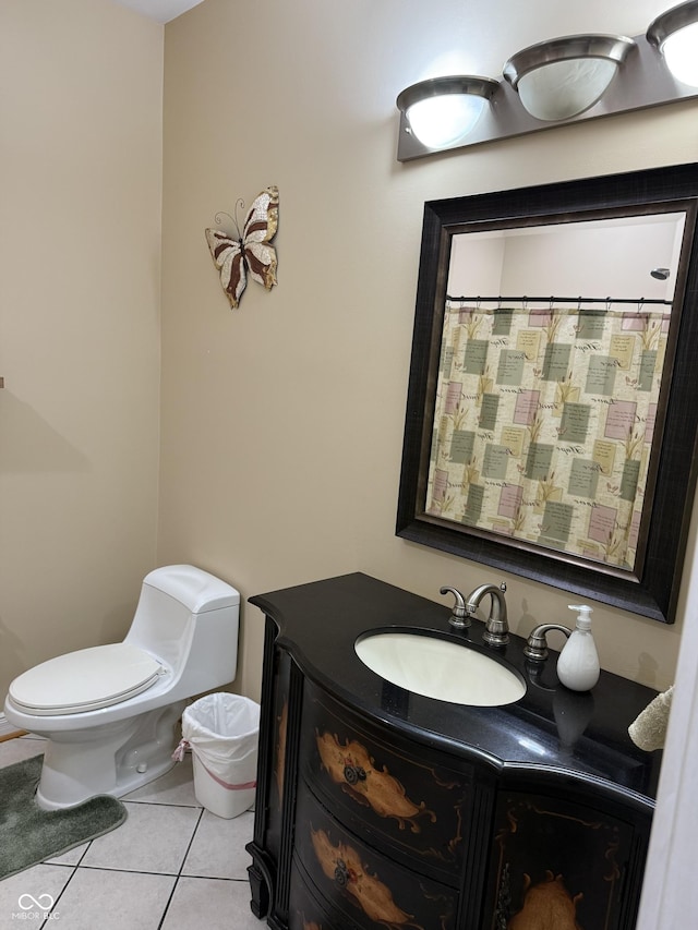 bathroom with toilet, vanity, and tile patterned floors