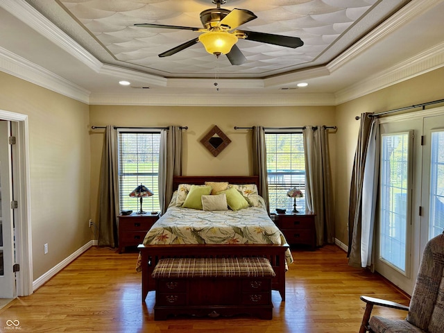 bedroom featuring crown molding, light wood-style flooring, baseboards, access to exterior, and a raised ceiling