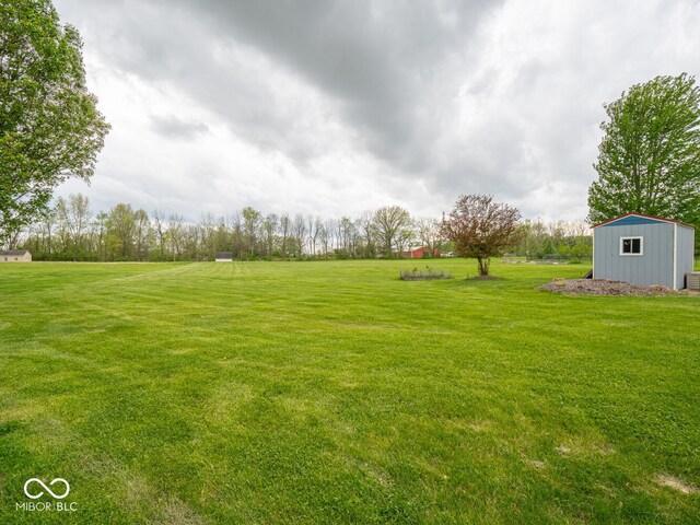 view of green lawn with an outbuilding