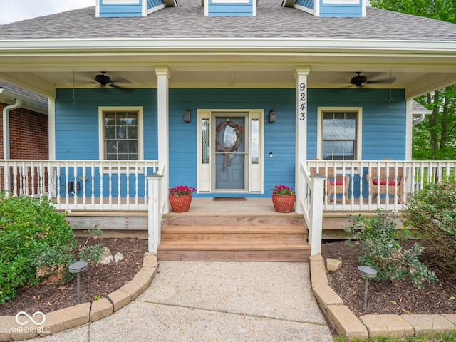 doorway to property with ceiling fan, roof with shingles, and a porch