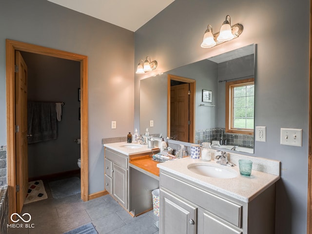 bathroom featuring double vanity, tile patterned floors, toilet, baseboards, and a bath