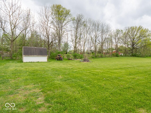 view of grassy yard with a storage shed and an outdoor structure