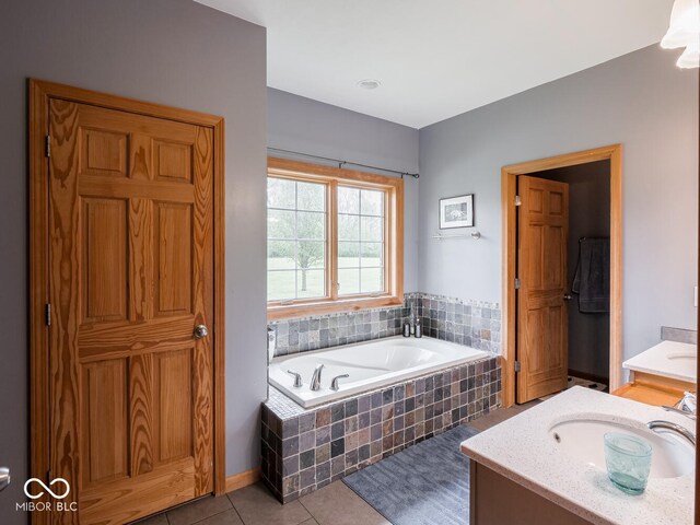 bathroom with tile patterned floors, a garden tub, and vanity