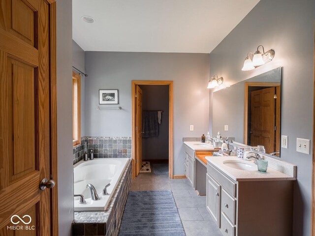 bathroom featuring tile patterned floors, double vanity, a garden tub, and baseboards