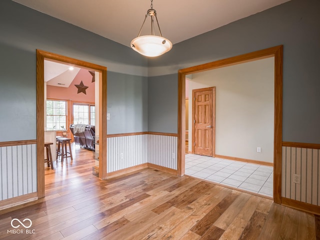 empty room featuring light wood finished floors and vaulted ceiling