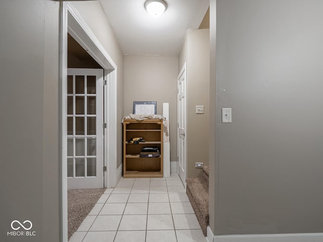 hallway with light tile patterned flooring and light colored carpet