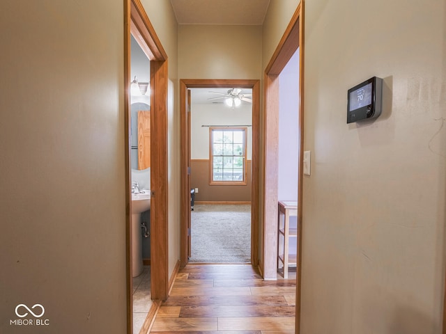 corridor with light wood finished floors and baseboards
