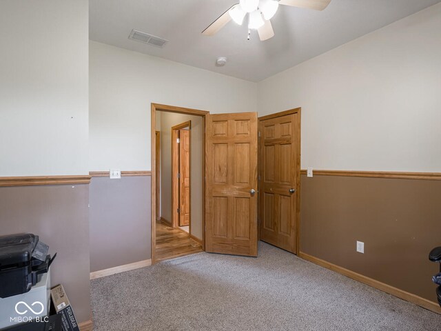 spare room featuring ceiling fan, carpet floors, and baseboards