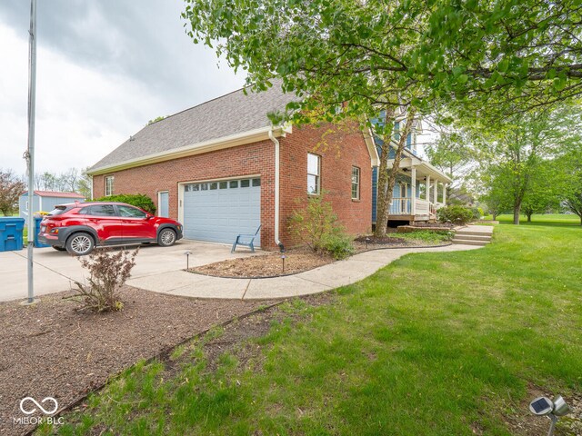 view of side of property with concrete driveway, a yard, brick siding, an attached garage, and a shingled roof