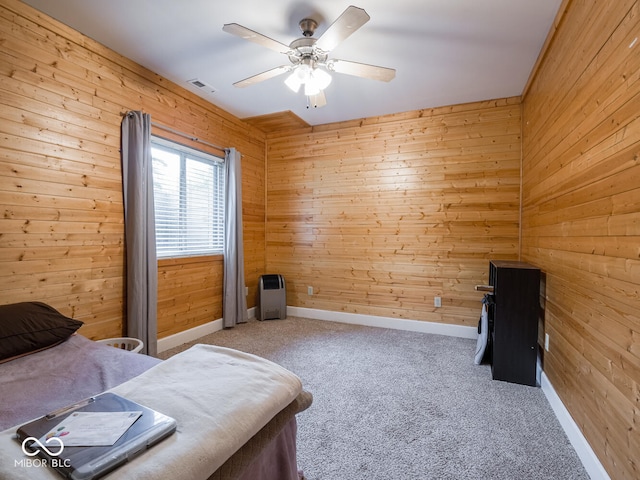 bedroom featuring wooden walls, carpet floors, a ceiling fan, and baseboards
