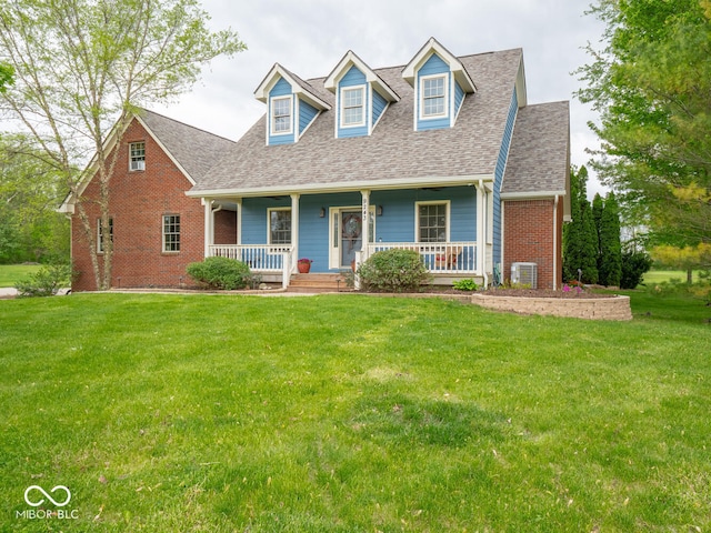 cape cod home featuring a shingled roof, a front yard, and covered porch