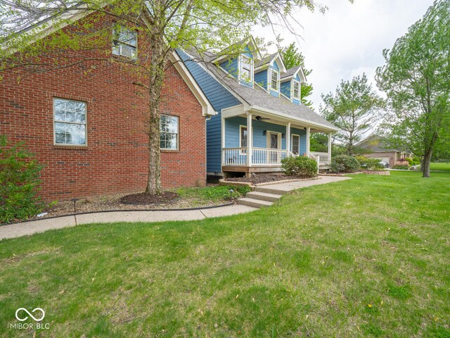 cape cod-style house with a porch, a front lawn, and brick siding