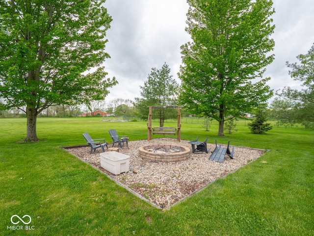 view of green lawn with a fire pit