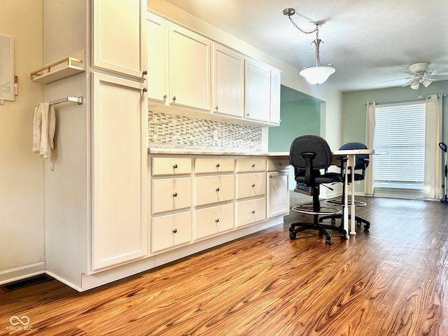 office space featuring visible vents, ceiling fan, light wood-style flooring, and baseboards