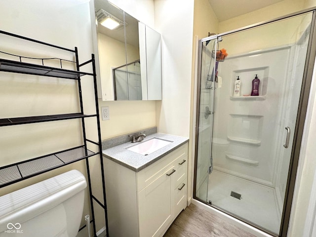 full bath featuring wood finished floors, toilet, vanity, visible vents, and a stall shower