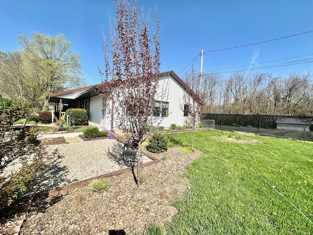 view of property exterior featuring fence and a yard