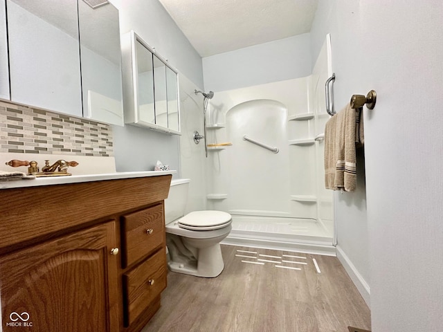 full bathroom with toilet, a walk in shower, wood finished floors, and tasteful backsplash