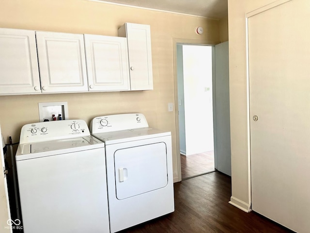 laundry area with baseboards, cabinet space, washing machine and clothes dryer, and dark wood-type flooring