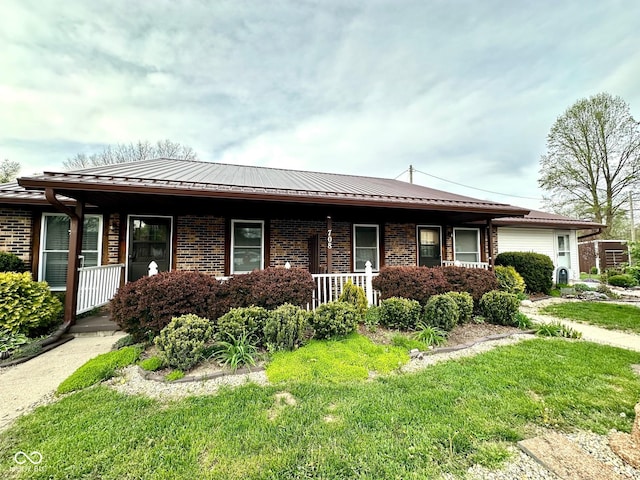ranch-style house featuring a porch, metal roof, and brick siding