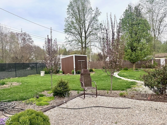 view of yard featuring a storage unit, an outbuilding, and a fenced backyard