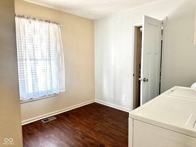 laundry room with independent washer and dryer, visible vents, dark wood-style flooring, and baseboards