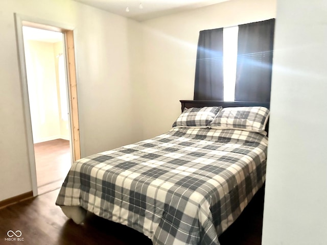 bedroom with baseboards and wood finished floors
