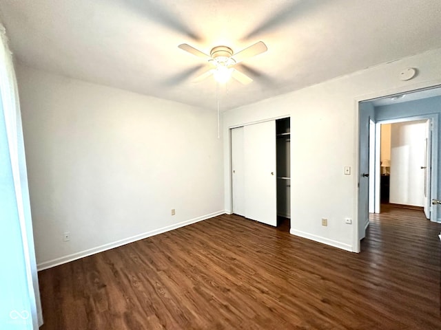 unfurnished bedroom with baseboards, ceiling fan, a closet, and dark wood-type flooring