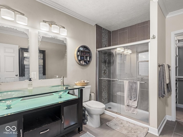 full bath featuring a textured ceiling, crown molding, a stall shower, vanity, and toilet