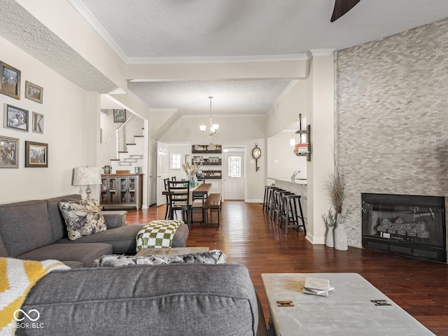 living area featuring an inviting chandelier, crown molding, wood-type flooring, and stairs