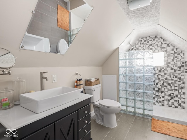 full bath with walk in shower, tile patterned flooring, vanity, toilet, and lofted ceiling