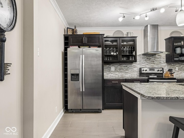 kitchen featuring backsplash, crown molding, appliances with stainless steel finishes, glass insert cabinets, and wall chimney exhaust hood