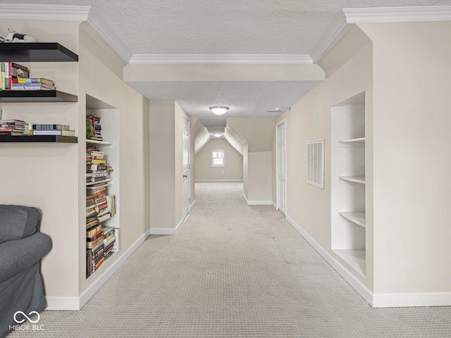 corridor featuring baseboards, light carpet, a textured ceiling, and built in shelves