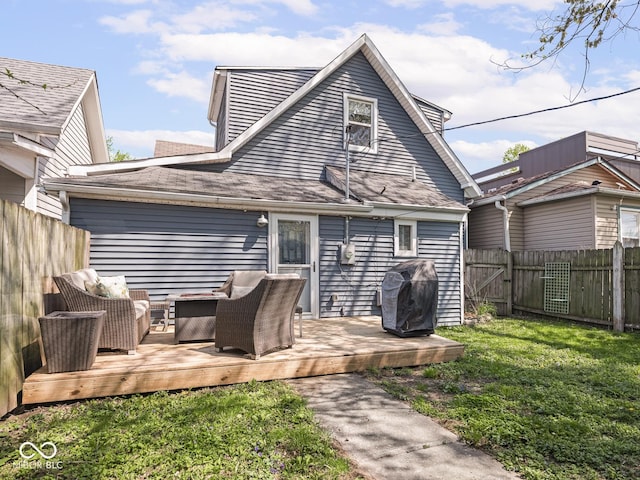rear view of property featuring an outdoor living space, a lawn, a wooden deck, a gate, and a fenced backyard