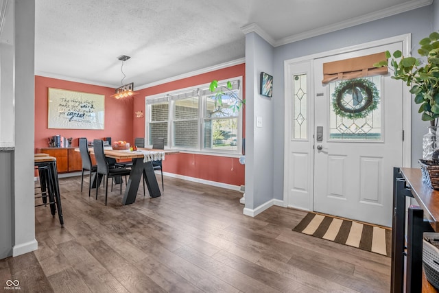 foyer with hardwood / wood-style flooring, baseboards, an inviting chandelier, and plenty of natural light
