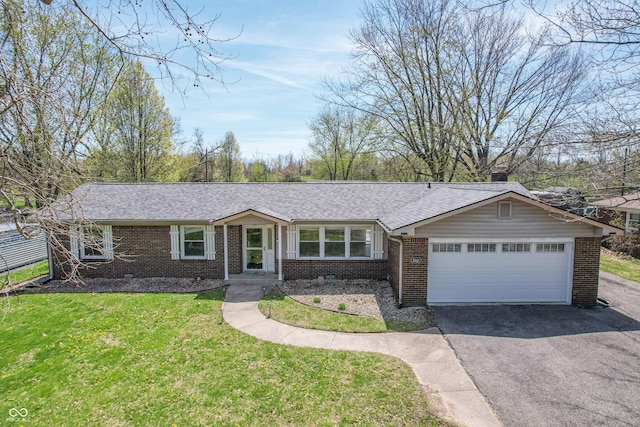 single story home with driveway, brick siding, a garage, a shingled roof, and a front yard