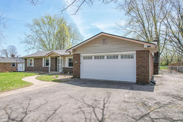 ranch-style house with a chimney, driveway, an attached garage, fence, and brick siding