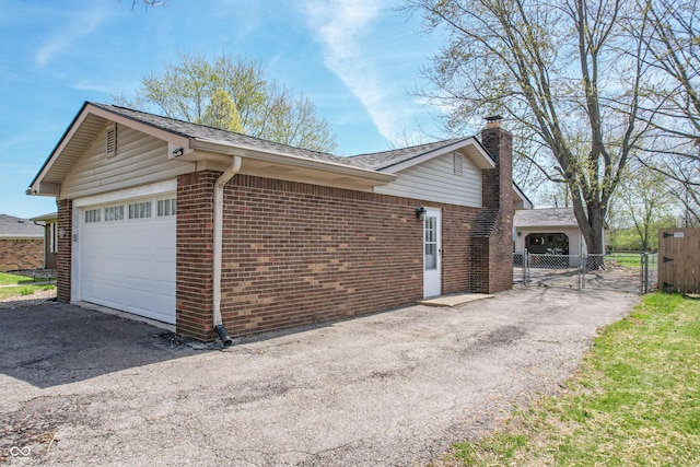 view of property exterior with a chimney, a gate, fence, a shingled roof, and brick siding