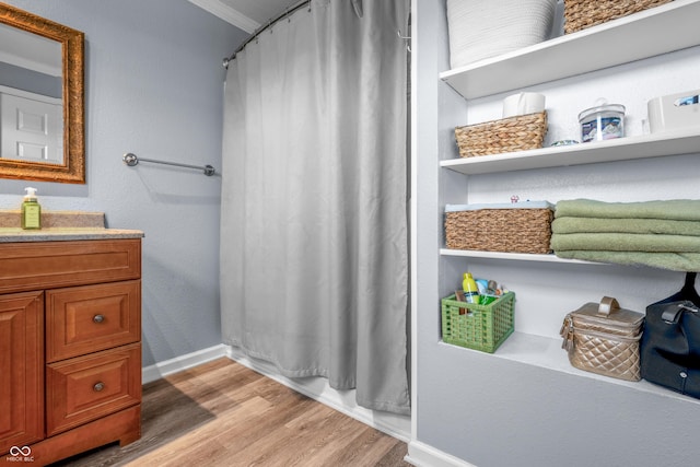 full bathroom with wood finished floors, vanity, baseboards, ornamental molding, and a shower with shower curtain