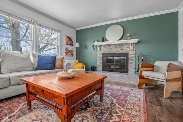 living area with hardwood / wood-style floors, a stone fireplace, and ornamental molding