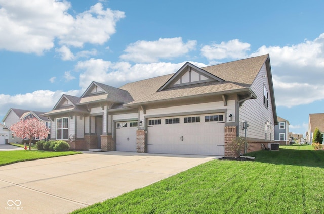 craftsman-style house with a front lawn, driveway, a garage, brick siding, and roof with shingles