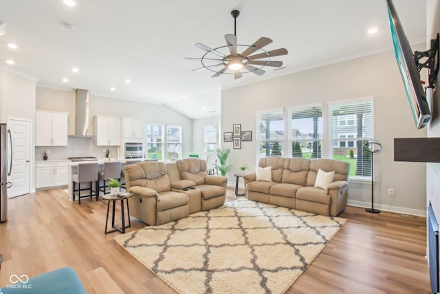 living room featuring a healthy amount of sunlight, a ceiling fan, baseboards, and ornamental molding