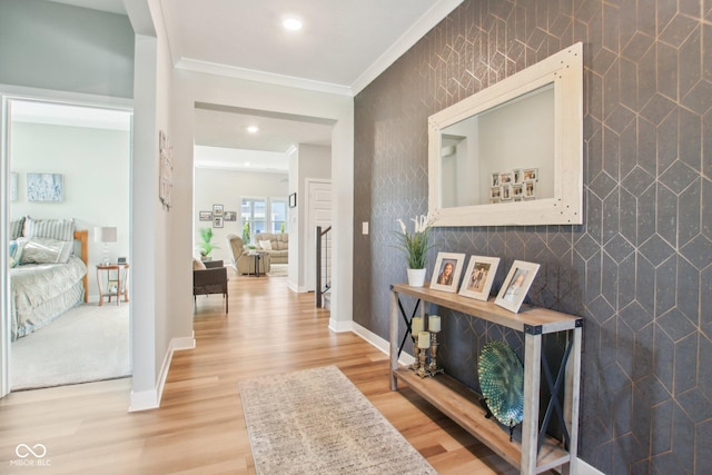 corridor with recessed lighting, wood finished floors, an accent wall, crown molding, and baseboards