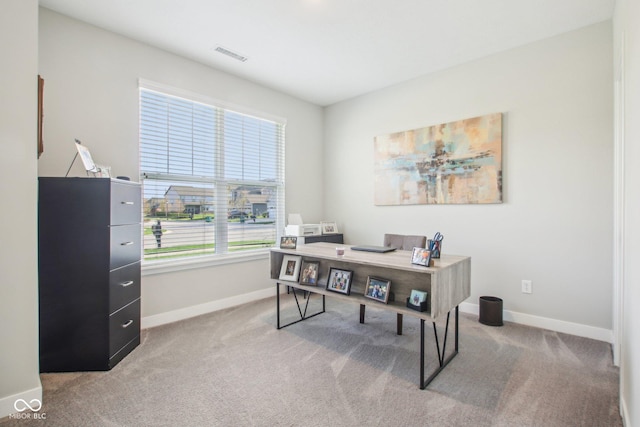 carpeted office space featuring baseboards and visible vents