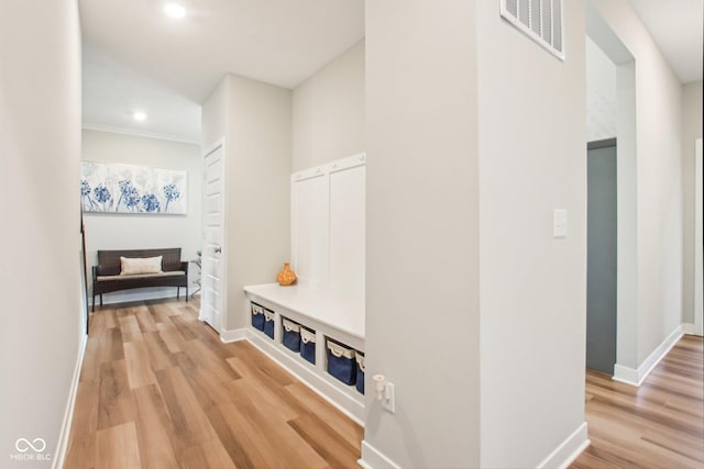 mudroom featuring light wood-style flooring, baseboards, ornamental molding, visible vents, and recessed lighting